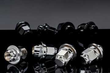 Shiny new wheel nuts on a dark background with reflection