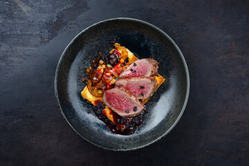 Traditional roasted Italian panettone tagliata di manzo with sliced beef steak and vegetable served as top view on a Nordic design plate with copy space