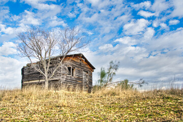 Wooden house charred and semi-destroyed by fire.