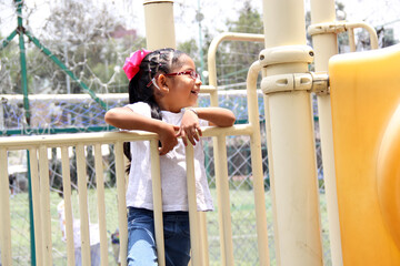 Little brunette latin woman girl with glasses plays outdoors in free games, happy, doing physical activity