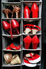 Many shoes sandals and high heeled footwear in closet organizer.