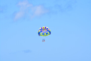 People parasailing high in the sky. 