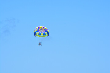 People parasailing high in the sky. 