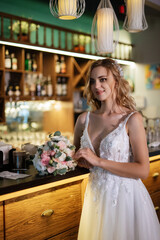 blonde bride in a bar near with a wedding bouquet