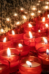 Rows of little red candles usually seen in churches, cathedrals and chapels.
