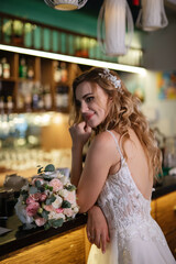 Naklejka premium blonde bride in a bar near with a wedding bouquet