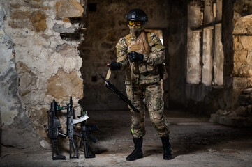 A woman in an army uniform holds a firearm in an abandoned building.