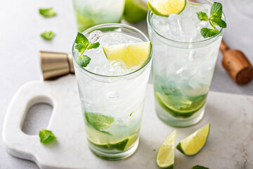 Classic mojito cocktail in tall glasses with lime and mint