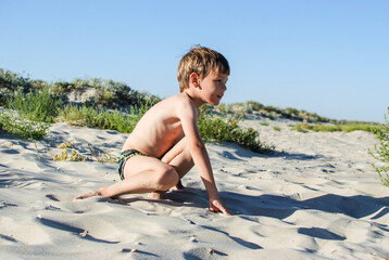 child playing with sand running jumping on the ocean