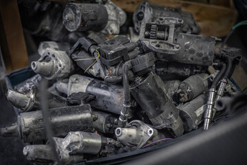 Pile of starters in a box at the salvage yard.