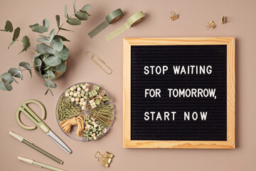 Flatlay of letter board with motivational quote Stop waiting for tomorrow, start now. Office supplies made of recycled materials on beige background.