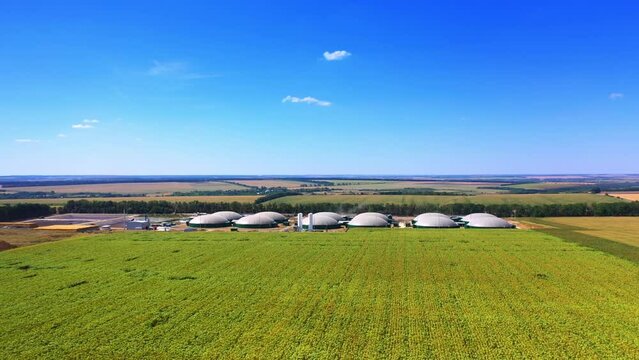 Modern bio fuel factory locating in the picturesque farmlands. Sunny summer day nature. Blue sky at backdrop. Top view.