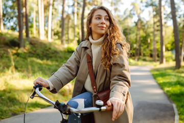 Fototapeta na wymiar Beautiful woman riding bicycle in park. Lifestyle. Relax, nature concept. Spring time.