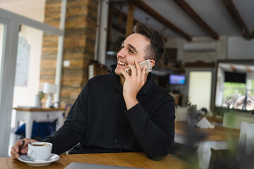 Obraz premium one man use mobile phone while sit at the table at restaurant