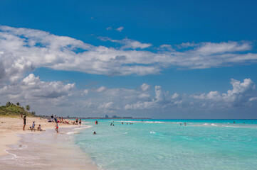 Fototapeta premium Varadero beach in Cuba in the year 2023. Blue sea, clear sky and many tourists on the beach.