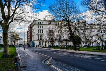 Fototapeta premium Brighton, UK, 25/02/2023: 'Palmeira Square' is a mid-19th-century residential development in Hove. View to the main shops and buildings