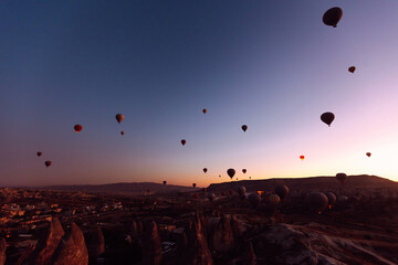 Flying hot air balloons rise in sunrise Cappadocia. Goreme National Park Turkey.