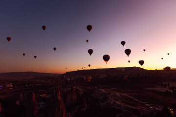 Flying hot air balloons rise in sunrise Cappadocia. Goreme National Park Turkey.