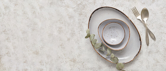 Stylish tableware and cutlery on light background with space for text