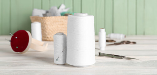 White threads with sewing supplies on table