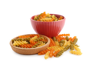 Bowl and plate of raw fusilli pasta on white background
