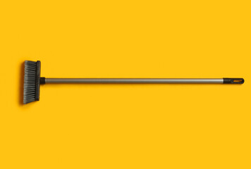 Plastic cleaning broom on yellow background