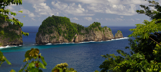 Natural rock formations of the Vai'ava Strait National Natural Landmark stretches out into the...