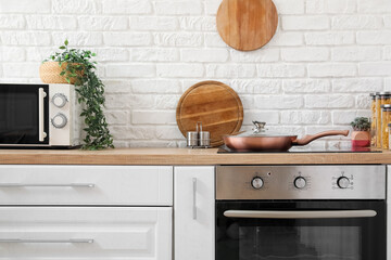 Frying pan on electric stove and oven in kitchen