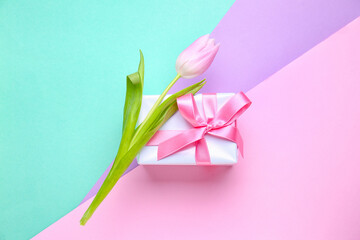 Beautiful tulip and gift for Women's Day celebration on color background