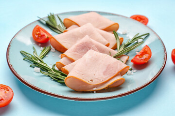 Plate with slices of tasty ham, tomatoes and rosemary on blue background