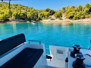 Beautiful turquoise waters on a sunny day seen from the bridge of a sailing catamaran at Spetsai...
