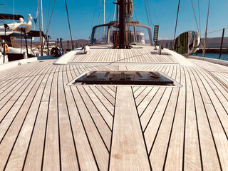 Bow-to-stern view of a First 53 performance sailboat with teak deck and a black mast and boom