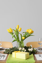 Table setting for International Women's Day celebration with gifts and tulip flowers on white background