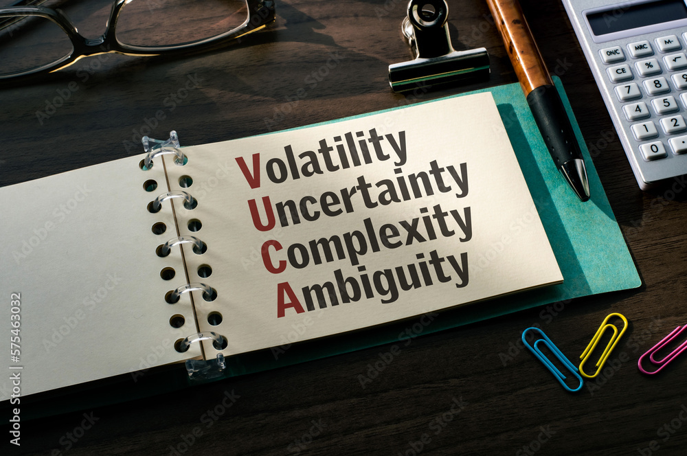 Poster there is a notebook with the word volatility, uncertainty, complexity, ambiguity. it is an eye-catch