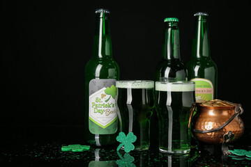 Glasses, bottles of beer and pot with golden coins on dark background. St. Patrick's Day celebration