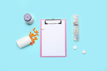 Fototapeta na wymiar Blank clipboard with pills on blue background. World Health Day