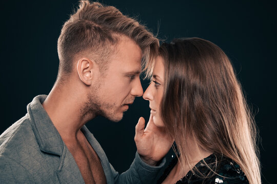 young sensual couple is lost in their own world of love and desire with hand on each others face they share an intimate moment, wrapped up in each other's embrace, lost in the passion of the present