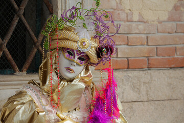 Fototapeta na wymiar City carnival mask, venetian carnival masks in gold costumes, traditional carnival in Venice, Italy.