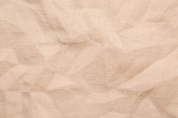 Closeup view of crumpled beige fabric as background