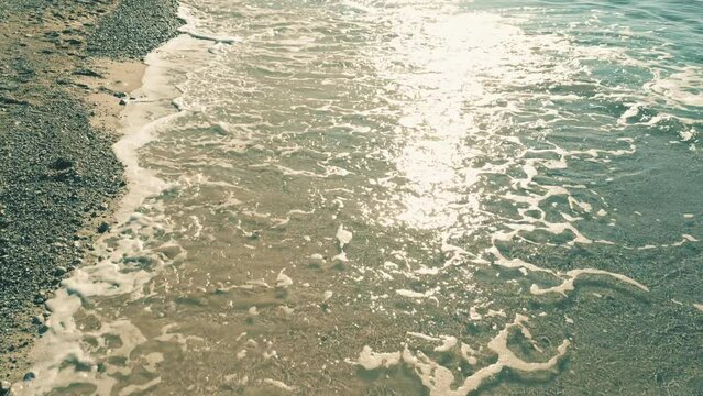 Low altitude aerial view of shallow water waves on the beach, slow motion