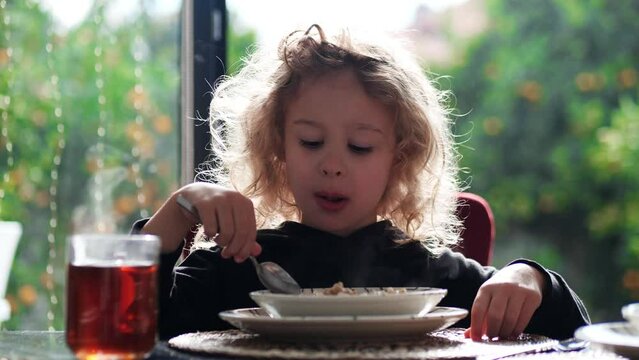 Little girl eats her healthy breakfast at home