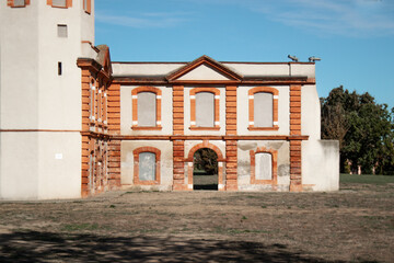 Façade of an old classic building. Brick architecture. Pediment over the blue sky.