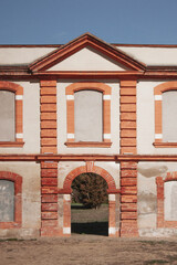 Façade of an old classic building. Brick architecture. Pediment over the blue sky.