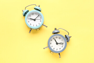 Alarm clocks on yellow background