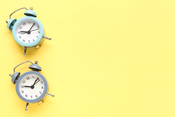 Alarm clocks on yellow background