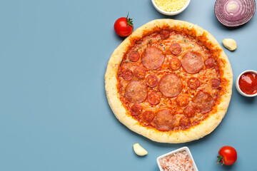 Delicious pepperoni pizza and ingredients on blue background
