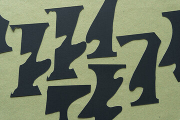 black paper shapes on rough green paper