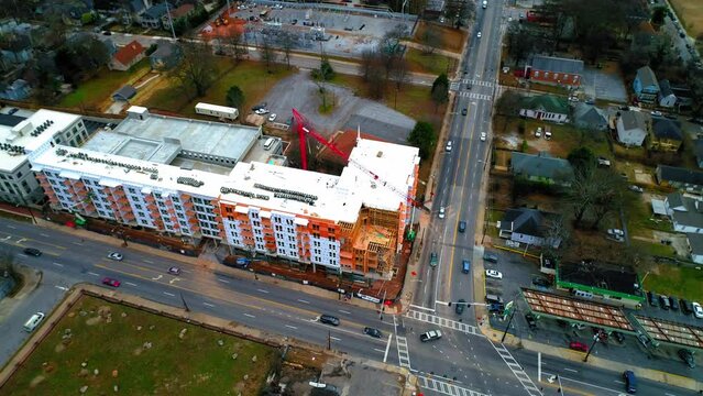 Aerial Panning Shot Of Cars Moving On Roads By Construction Site Under Development Buildings In City - Atlanta, Georgia