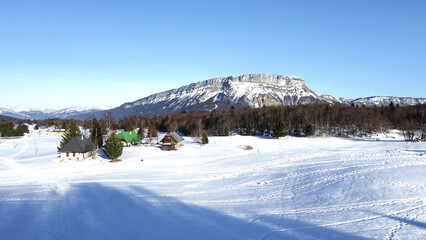 Panoramic view of snowy mountains in winter. Foggy mountains. Woods in front of the mountains. Mountains resort station.