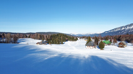 Panoramic view of snowy mountains in winter. Foggy mountains. Woods in front of the mountains. Mountains resort station.